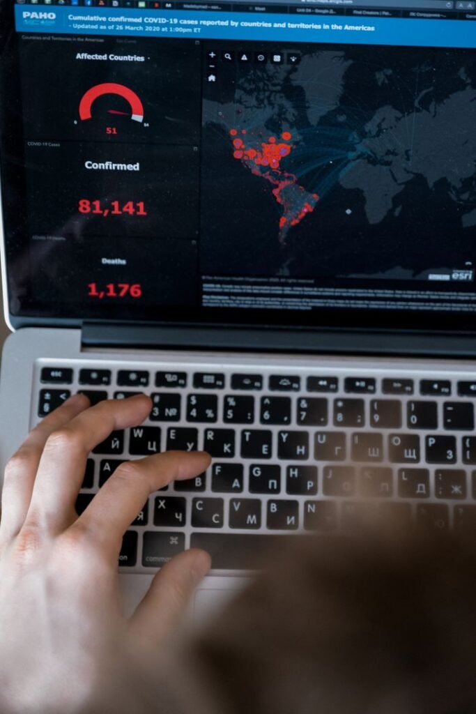 Person using laptop to view COVID-19 data map and statistics.